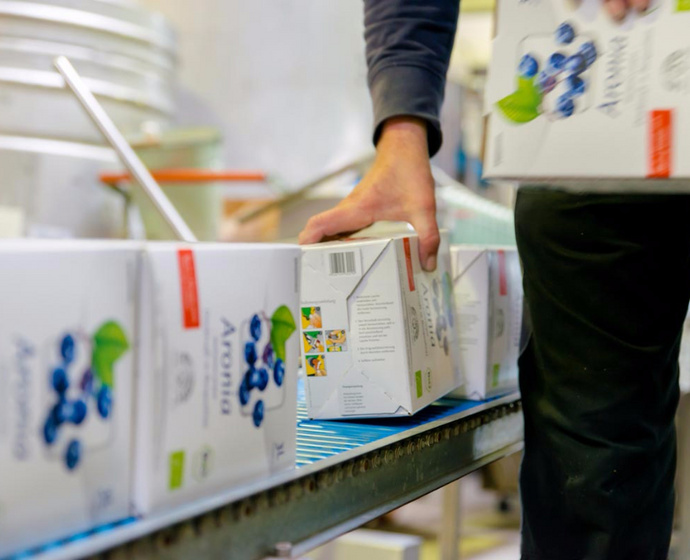 [Translate to Englisch:] Aronia-Saftboxen auf dem Fliessband