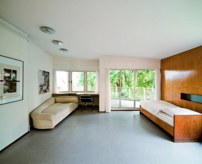 Bedroom in the Schminke House including bed, couch, desk and terrace door.