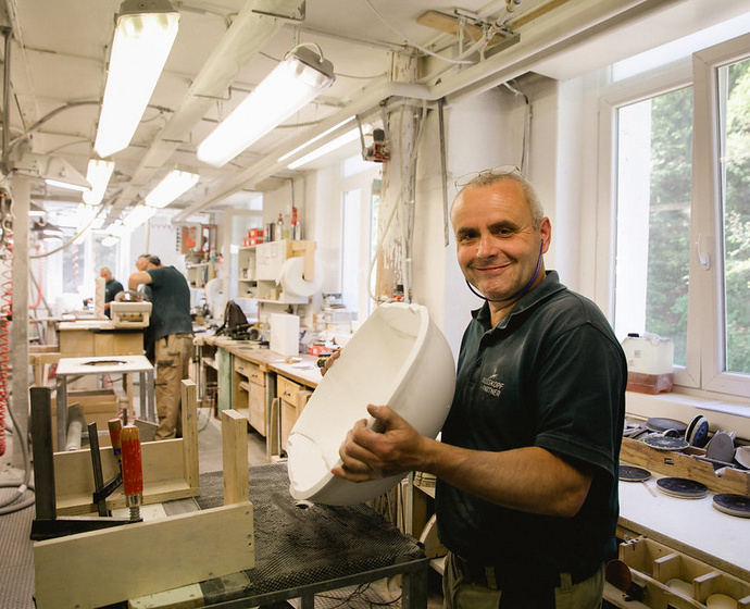 Mitarbeiter mit Keramikprodukt in der Werkstatt